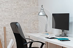 Contemporary stylish designer workplace with desktop computer, notebook, gadgets and office supplies. Copy space