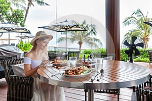 Contemporary tropical restaurant setting with female