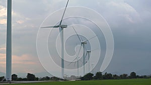 Contemporary windmills row generate energy with blades