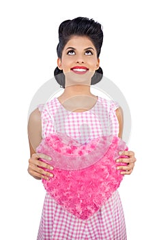 Content black hair model holding a pink heart shaped pillow