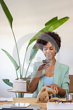 Content blackwoman photographing product in office