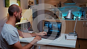 Content creator working on laptop during night time .