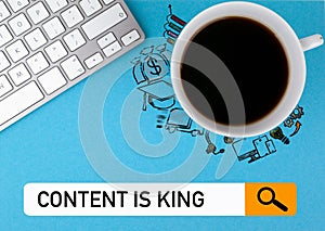 Content is king concept. On a blue background coffee mug and computer keyboard