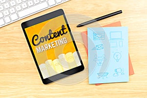 Content Marketing word on tablet screen with icon on blue notebook at wood table, Digital Marketing concept