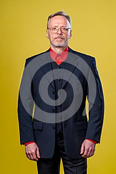 Content senior business man smiling in a dark suit. Hands straight. Red shirt. Confident. Business style concept