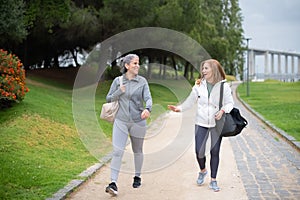 Content senior friends walking in park