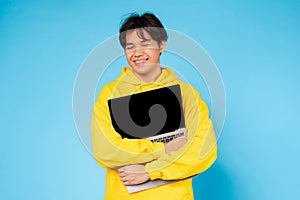 Content teen holding laptop with screen visible