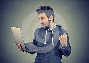 Content victorious man with laptop