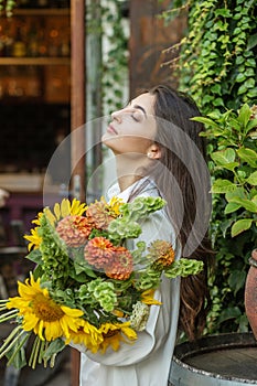 Content Woman with a Bouquet of Seasonal Flowers