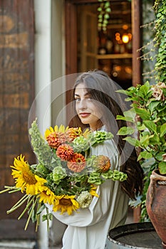 Content Woman with a Bouquet of Seasonal Flowers