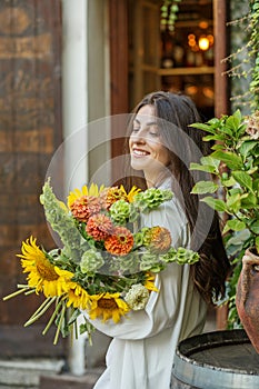 Content Woman with a Bouquet of Seasonal Flowers