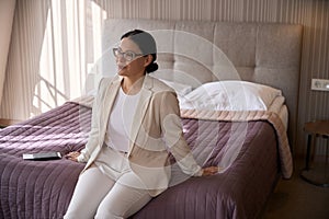 Contented businesswoman sitting in her suite upon arrival