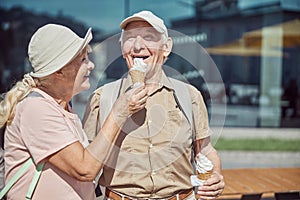 Contented man eating dessert from his wife hand