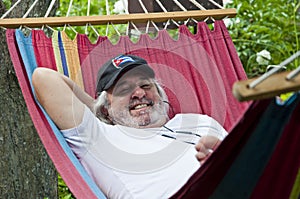Contented old man finding solace in a hammock. Blissful relaxation for the old man in the hammock. Serene old man enjoying a