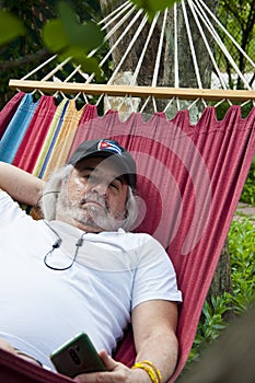 Contented old man finding solace in a hammock. Blissful relaxation for the old man in the hammock. Serene old man enjoying a