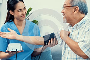 A contented retired man having a blood pressure check by his personal caregiver.