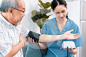 A contented retired man having a blood pressure check by his personal caregiver.