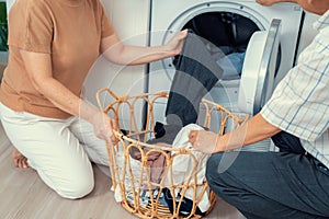 Contented senior couple doing laundry together.