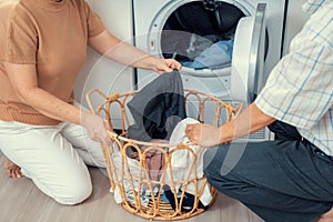 Contented senior couple doing laundry together.