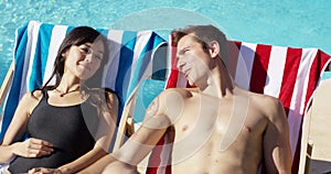 Contented young couple smiling as they sunbathe