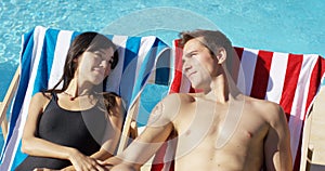 Contented young couple smiling as they sunbathe