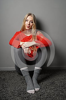 Contented young woman sitting on floor in her room photo