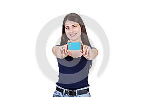 Contented young woman presents a credit card to camera, isolated on white background with copy space. Girl advertising her