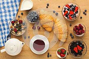 Continental breakfast with croissants and berries on natural woo