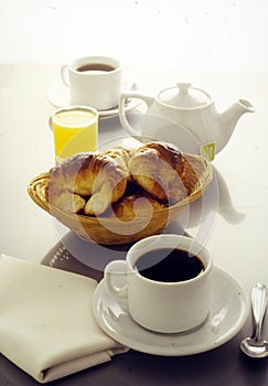 continental breakfast of cup of coffee with croissants orange juice and tea cup white background