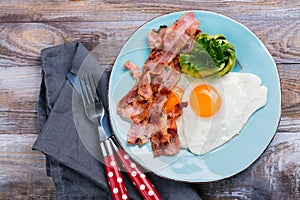 Continental breakfast with fried eggs, bacon and avokado