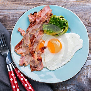 Continental breakfast with fried eggs, bacon and avokado