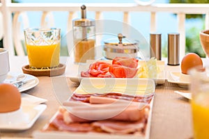 Continental morning breakfast table setting with sea view is served.