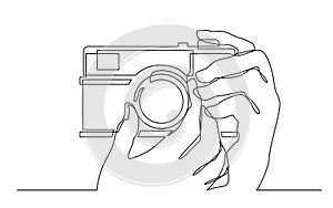 Continuous line drawing of hand holding photo camera making pictures