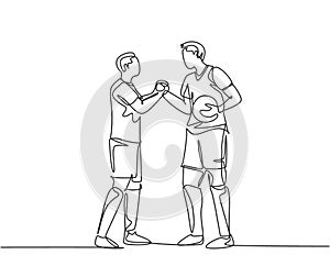 Continuous line drawing of two football player bring a ball and handshaking to show sportsmanship before starting the match.