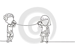 Continuous one line drawing boy and girl play toy phone. Two friends playing in phone with self made speech transmitting device,