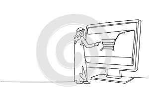 Continuous one line drawing young Arabian man shopping through monitor screen with shopping cart. E-shop, e-commerce, digital