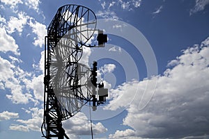 Contour small military radar station on background beautiful clouds and sky. Mobile relay station, Russia