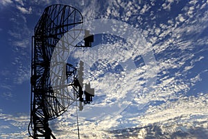 Contour small military radar station on background beautiful clouds and sky. Mobile relay station, Russia