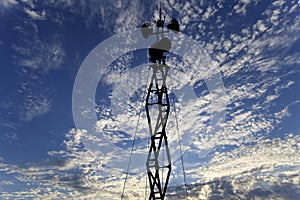 Contour small military radar station on background beautiful clouds and sky. Mobile relay station, Russia