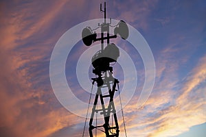 Contour small military radar station on the background of the sunset orange sky. Mobile relay station, Russia