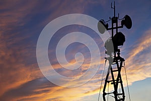 Contour small military radar station on the background of the sunset orange sky. Mobile relay station, Russia