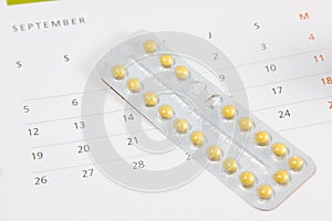 Contraceptive pills on a calendar. photo