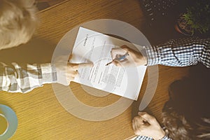 Contract document, two men sign paper in the office a toned faded image