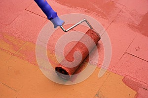 Contract painter painting a floor with a paint roller