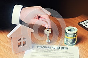 Contract for the purchase of a house. The real estate agent holds the keys. house model and dollars. Property investment. buying,