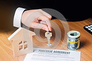 Contract for the purchase of a house. The real estate agent holds the keys. house model and dollars. Property investment. buying,