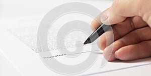 Contract signing concept. Businessman hand with pen over document closeup