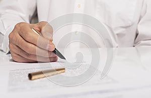 Contract signing concept. Businessman hand with pen over document closeup