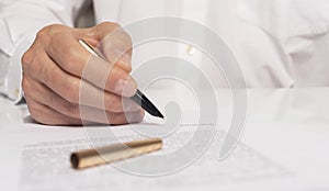 Contract signing concept. Businessman hand with pen over document closeup