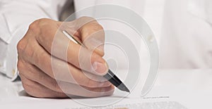 Contract signing concept. Businessman hand with pen over document closeup